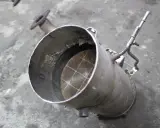 Filtr DPF z widocznym wkładem ceramicznym i rurką.